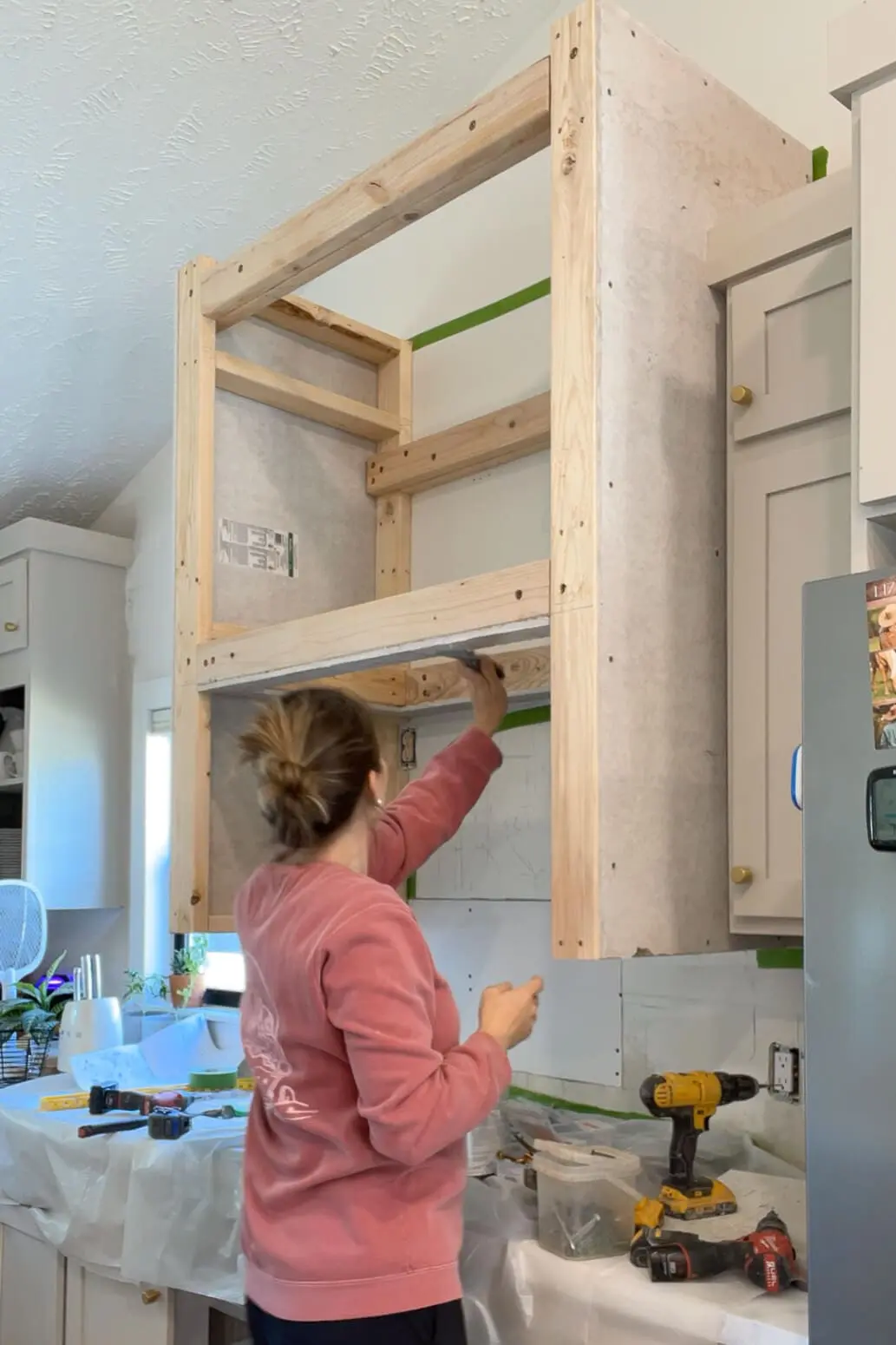 Woman adding venetian plaster to range hood.